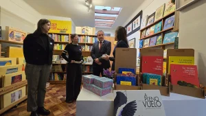 El gerente general de Sercotec, la secretaria ejecutiva de Economía Creativa y dos representantes de la cooperativa Clic conversan y observan diferentes productos culturales expuestos sobre una mesa en la librería.