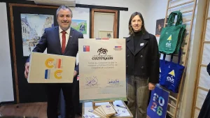 El gerente general de Sercotec y la secretaria ejecutiva de Economía Creativa posan junto al cartel de compromiso ya firmado, sosteniendo también una caja ilustrada de la cooperativa Clic.