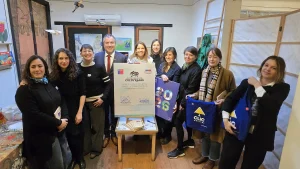 Una fotografía grupal con diez personas, incluidas autoridades y representantes de la cooperativa Clic, posando junto al cartel de compromiso firmado y sosteniendo bolsas y otros productos de la cooperativa.