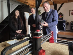 El gerente general de Sercotec examina atentamente una pieza impresa en 3D mientras conversa con la fundadora de Cachivarte y el director regional de Sercotec.