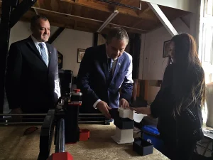 El gerente general de Sercotec y la fundadora de Cachivarte trabajan juntos para ensamblar una pieza impresa en 3D sobre una mesa de trabajo.