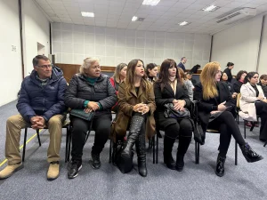 Un grupo de personas, principalmente mujeres, sentadas en la primera fila de un auditorio escuchando atentamente. Visten ropa de abrigo. Se trata de representantes de las cooperativas rurales beneficiarias durante la ceremonia.