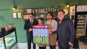 El ministro de Economía y el gerente general de Sercotec posan junto a los dueños de Inti Mapu, sosteniendo juntos un letrero colorido que dice "Pymes en MODO EMPLEO".