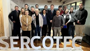 Fotografía grupal del gerente general de Sercotec junto a representantes de ferias libres y directivos de Lo Valledor tras una reunión de trabajo, posando sonrientes en una sala de reuniones frente a letras corpóreas del logo de Sercotec.